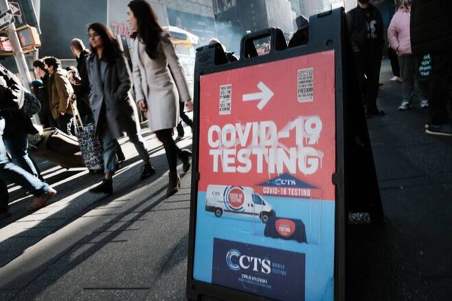 5일 행인들로 붐비는 미국 뉴욕의 타임스스퀘어에 코로나19 바이러스 검사소를 알리는 입간판이 서 있다. 뉴욕/AFP 연합뉴스