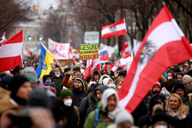 오스트리아 빈 시민들이 지난 4일 코로나 19 방역 조치에 반대하는 가두 시위를 벌이고 있다. "건강한 것은 범죄가 아니다"라고 쓴 피켓이 보인다. 로이터=연합뉴스