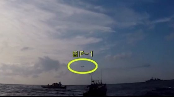2018년 12월 20일 조난 선박 구조작전 중인 해군 광개토대왕함 상공에 일본 초계기(노란 원)가 저공으로 비행하고 있다. 일본은 명확한 이유를 밝히지 않은채 한국의 잘못이라고만 주장하고 있다. 국방부 유튜브 캡처=연합