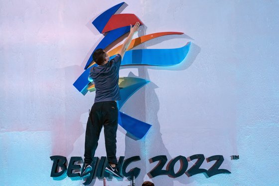 지난 9월 한 관계자가 베이징 올림픽 로고를 만지는 모습. AP/Mark Schiefelbein. 연합뉴스.