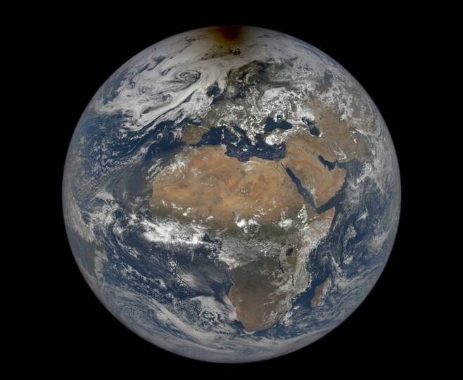 지난 6월 10일 DSCOVR 위성이 촬영한 지구의 일식 모습. 북극 부근에 검게 보이는 것이 달 그림자다. 사진=NASA