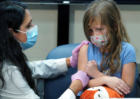 - 3일(현지시간) 미국 코네티컷주 스토스에서 6세 여아가 화이자-바이오엔테크의 코로나19 백신 첫 접종을 앞두고 겁먹은 표정을 짓자 의사가 달래며 접종을 준비하고 있다.로이터 연합뉴스 2021-11-04