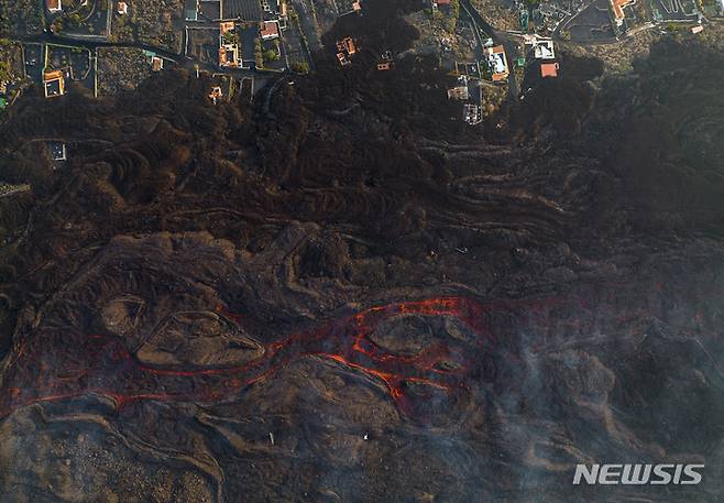 [라팔마=AP/뉴시스] 6일(현지시간) 스페인 카나리아제도 라팔마섬의 쿰브레 비에하 화산에서 흘러나온 용암으로 인해 라스 만차스 마을 주택이 훼손돼 있다. 2021.12.08.