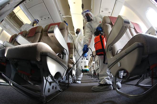 9일 인천국제공항 아시아나항공 격납고에서 관계자들이 A330 기내 방역소독을 하고 있다. 공동취재사진
