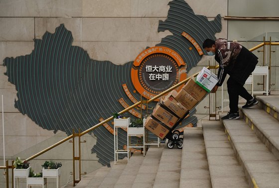 지난 8일 중국 베이징에 있는 헝다 그룹이 건설한 한 쇼핑몰에서 한 노동자가 짐을 운반하고 있다. [AFP=연합뉴스]