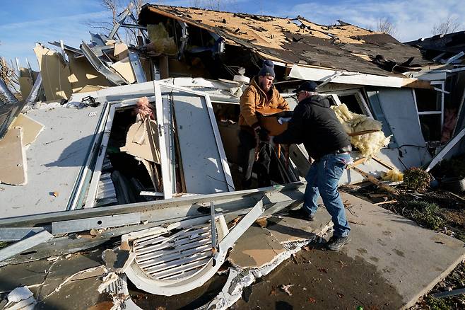 미 중부지역을 휩쓴 토네이도 피해를 입은 켄터키주 메이필드 주민들이 생활 도구를 나르고 있다/ AP연합뉴스