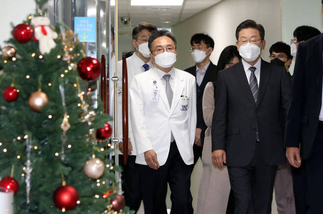 이재명 더불어민주당 대선 후보(오른쪽)가 15일 서울 동작구 보라매병원을 방문해 병원 관계자들과 걸어가고 있다. 국회사진기자단