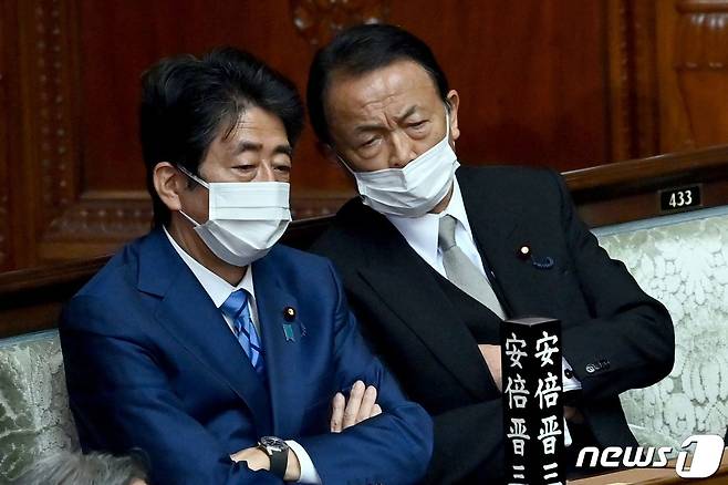아베 신조 전 일본 총리가 10일 (현지시간) 도쿄 중의원의 총리 선출 회의에 참석해 아소 다로 전 부총리와 얘기를 하고 있다. © AFP=뉴스1 © News1 우동명 기자