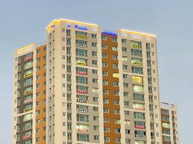 위례호반써밋 아파트 창문마다 호반산업의 조기 분양전환 등을 규탄하는 현수막이 붙어 있는 모습. 호반써밋분양대책위원회 제공