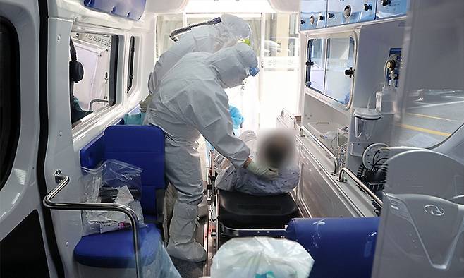 28일 경기도 성남시 국군수도병원 응급실에서 의료진이 코로나19 확진 환자를 이송하고 있다. 연합뉴스
