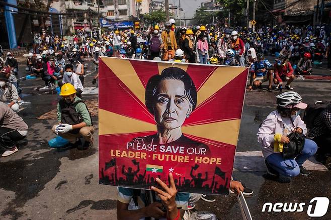 (AFP=뉴스1) 우동명 기자 = 3월 2일(현지시간) 미얀마 양곤에서 군부 쿠데타 규탄 시위대가 아웅산 수치의 사진을 들고 경찰의 진압을 대비하고 있다.  (C) AFP=뉴스1