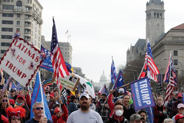 지난해 12월 미국 워싱턴에서 도널드 트럼프 전 미국 대통령 지지자들이 성조기와 깃발을 들고 대선 불복 시위를 벌이고 있다. 워싱턴=AP 연합뉴스