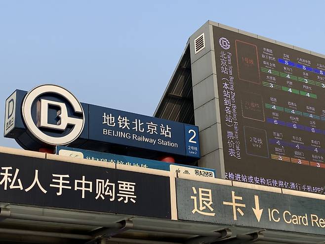중국 베이징 지하철 2호선 베이징기차역(北京站 베이징잔)의 영문 표기가 ‘Beijing Railway Station(베이징 레일웨이 스테이션)’에서 중국어 병음인 ‘Beijing Zhan(베이징 잔)’으로 바뀌었다. 교체 작업이 진행되면서 왼쪽 표지판엔 옛 표기가, 오른쪽 디지털 전광판엔 새 표기가 함께 보이고 있다. /김남희 특파원