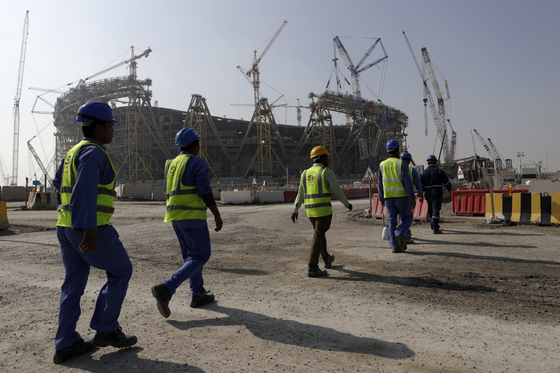 노동자들이 카타르 월드컵 주 경기장인 루사일 스타디움 건설 현장으로 향하고 있다. [AP=연합뉴스]