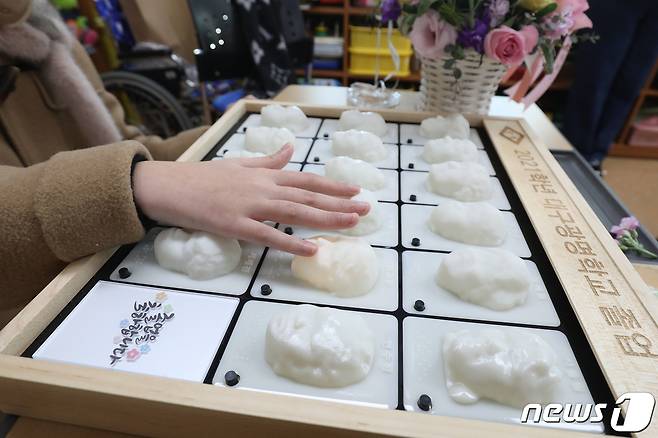 11일 오전 대구 남구 대명동 시각장애인 교육기관 대구광명학교에서 열린 2021학년 졸업식에서 초등학교 과정 졸업생이 3D프린터로 제작된 졸업앨범에 손을 올려 친구와 선생님 얼굴을 만져보고 있다. 대구광명학교는 크리에이티브팩토리의 도움을 받아 졸업생에게 친구와 선생님의 얼굴과 음성파일이 담긴 특별한 졸업앨범을 선물했다. 2022.1.11/뉴스1 © News1 공정식 기자