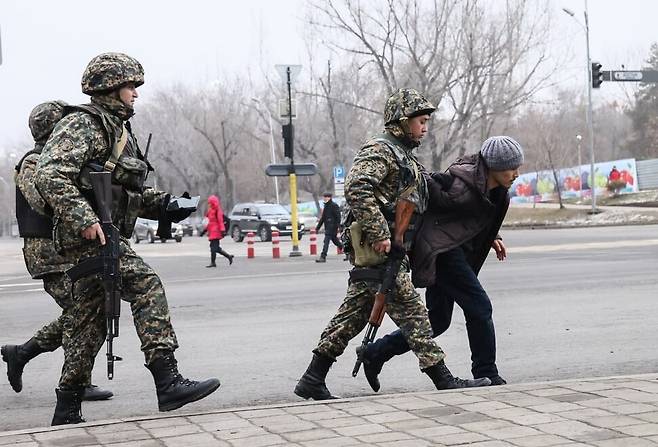 10일 카자흐스탄 수도 누르술탄에서 거리를 순찰하던 병사들이 한 남성을 붙잡아 어디론가 끌고 가고 있다. 누르술탄/타스 연합뉴스
