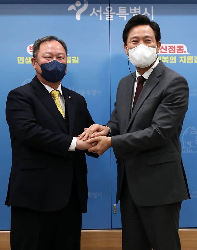 오세훈 서울시장(오른쪽)과 김인호 서울시의회 의장이 12일 오전 서울 중구 서울시청에서 열린 '서울시 민생지킴 종합대책 발표'에서 손을 맞잡고 기념촬영을 하고 있다. /뉴시스