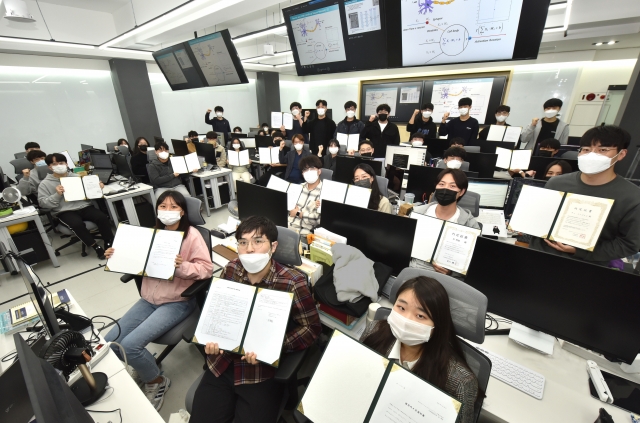 전원 일본기업 취업이 내정된 영진전문대 일본IT과 올해 졸업예정 학생들이 대학 실습실서 내정서를 펼쳐보이고 있다. 영진전문대 제공