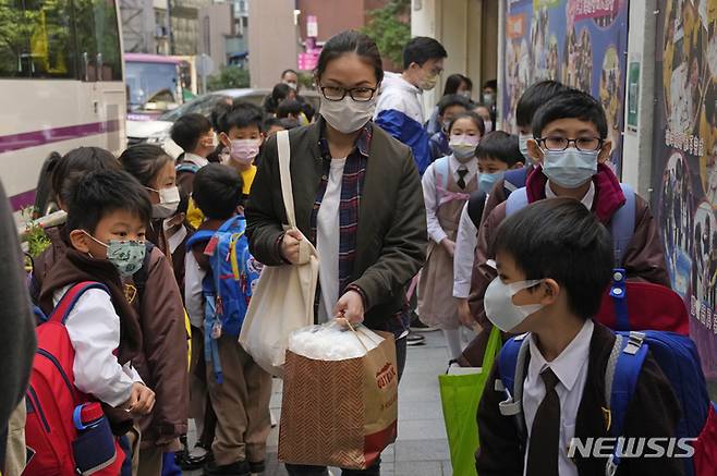 [홍콩=AP/뉴시스] 11일 홍콩에서 초등학교 학생들이 학교 버스를 타기 위해 줄 서 있다. 캐리 람 홍콩 행정장관은 어린이의 코로나19 감염 사례가 늘면서 유치원과 초등학교를 일정 기간 폐쇄한다고 밝혔다. 이에 따라 해당 학생들은 14일부터 최소 2월 첫째주 설 연휴까지 등교하지 않는다. 2022.01.11