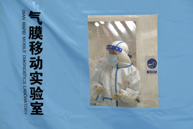 지난 11일 중국 톈진의 코로나19 임시 검사소에서 작업자가 시험에 몰구하고 있다. /AP연합뉴스