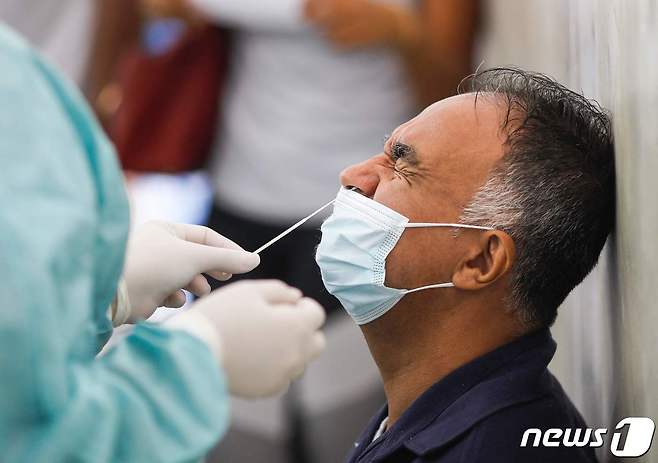 브라질 수도 브라질리아 시내 한 버스 정류장에서 한 남성이 신종 코로나바이러스 감염증 진단검사를 받고 있다. 2022.01.07 © AFP=뉴스1