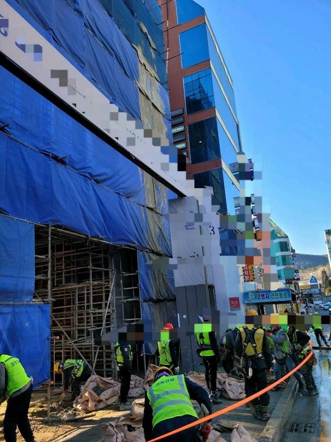 13일 오후 3시쯤 부산 해운대구 우동 경동리인아파트 공사장에서 타설 중인 콘크리트가 아파트 외벽을 타고 흘러내려 작업자들이 현장을 정리하고 있다.   부산경찰청 제공
