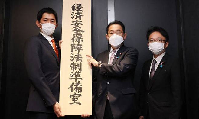 기시다 후미오 일본 총리(가운데)와 고바야시 다카유키(왼쪽) 경제안전보장담당상이 지난해 11월19일 경제안전보장법제준비실 현판을 들어 보이고 있다. 일본총리광보실