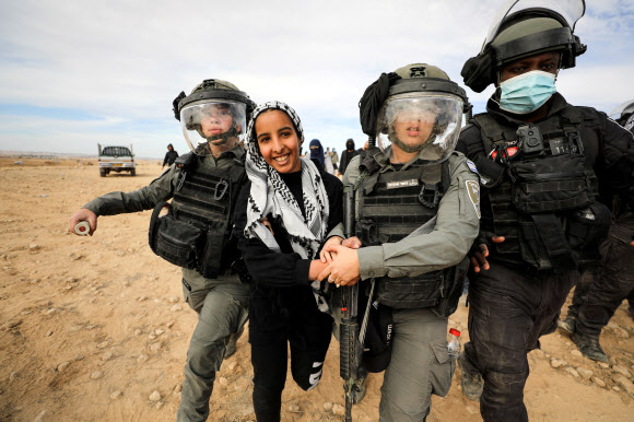 12일(현지시간) 이스라엘 남부 네게브 사막의 베르셰바 인근에서 한 베두인 여성이 사막 녹지화에 반대하는 시위를 벌이던 중 이스라엘 보안군에게 체포되고 있다. 베르셰바 로이터 연합뉴스