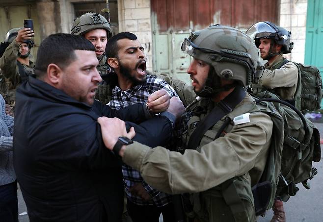 지난 7일 요르단강 서안에 위치한 헤브론의 도심에서 이스라엘 군인이 팔레스타인 시위자들을 구금하는 과정에 몸싸움을 벌이고 있는 모습. 이스라엘은 헤브론에 있는 정착민들을 보호한다는 명분으로 이곳에 군대를 주둔시켜 왔다. EPA/ABED AL HASHLAMOUN/연합뉴스