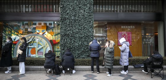 지난 5일 서울 시내 한 백화점의 명품 매장 앞에 고객들이 줄 서서 입장하길 기다리고 있다. 한국의 MZ세대는 명품이나 플렉스 같은 단어로 언론에 소비되는 경우가 많다. [뉴시스]