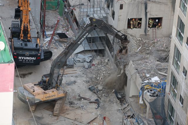 광주 서구 화정동 신축아파트 붕괴사고 나흘째인 14일 관계자들이 잔해물을 치우고 있다. 연합뉴스