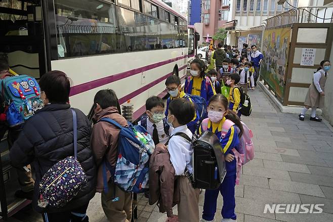 [홍콩=AP/뉴시스] 11일 홍콩에서 초등학교 학생들이 학교 버스를 타기 위해 줄 서 있다. 캐리 람 홍콩 행정장관은 어린이들의 코로나19 감염 사례가 늘면서 유치원과 초등학교를 일정 기간 폐쇄한다고 밝혔다. 이에 따라 해당 학생들은 오는 14일부터 최소 2월 첫째 주 설 연휴까지 등교하지 않는다. 2022.01.11.