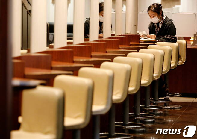 일본 도쿄도의 한 카페에서 지난 11일 한 여성이 마스크를 착용한 채 앉아있다. © 로이터=뉴스1 © News1 원태성 기자