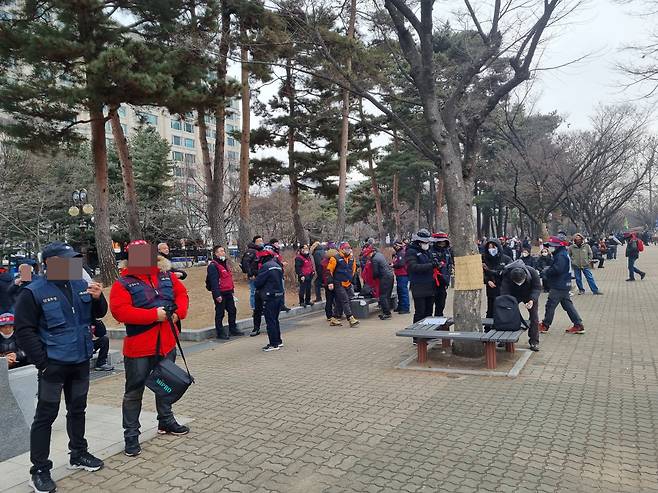 15일 오후 서울 영등포구 여의도공원 문화의 마당에서 전국민중행동이 주최한 민중총궐기가 열렸다. 일부 참가자가 여의도공원 바깥쪽 벤치에서 마스크를 내린 채 담배를 피우고 있다. 김영철 기자