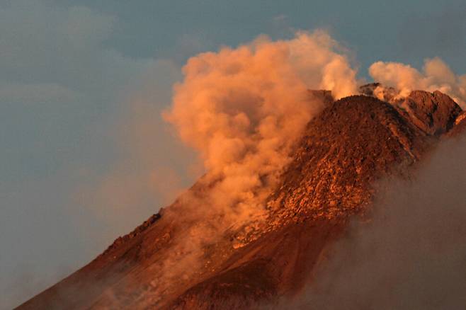 인도네시아 자바섬 중부 족자카르타의 므라피 화산이 지난해 12월29일(현지시간) 분화해 화산재와 연기를 토해내고 있다. 높이 2천930m의 므라피 화산은 인도네시아의 120여 개 활화산 가운데 화산활동이 가장 활발하다. 2010년 10월에는 이 화산이 폭발해 주민 350여 명이 숨지기도 했다. 연합뉴스