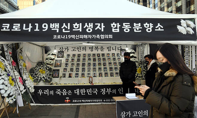 ‘코로나19 백신 피해자 가족협의회’가 서울 중구 청계광장에 코로나19 백신 희생자 합동분향소를 설치한 가운데 16일 한 시민이 합동분향소 앞을 지나가고 있다. 서상배 선임기자