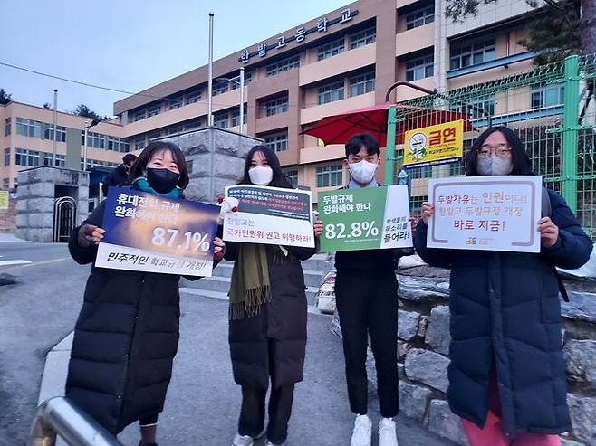 2021년 12월24일 대전 한밭고 교문 앞에서 김난웅 학생(오른쪽에서 두번째)과 인권단체 관계자들이 학교 쪽에 인권위 권고 이행을 요구하는 피켓 시위를 하고 있다. 사진 김난웅 학생 제공