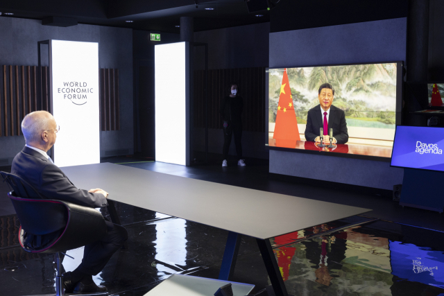클라우스 슈밥 다보스포럼 회장이 17일 시진핑 중국 국가주석의 화상연설을 지켜보고 있다. /AP연합뉴스