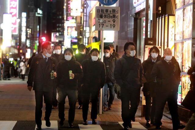일본의 코로나19 하루 확진자 수가 4만명을 넘은 19일 식당과 주점이 많은 도쿄의 한 번화가를 마스크를 쓴 시민들이 걸어가고 있다. 도쿄=AP 연합뉴스