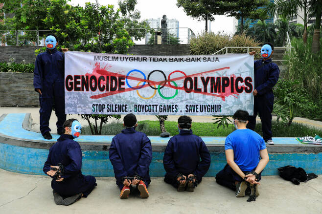 지난 4일(현지시간) 인도네시아 자카르타의 한 공원에서 활동가들이 등 뒤로 수갑을 찬 채 베이징 동계올림픽에 대한 보이콧을 촉구하며 시위를 벌이고 있다. 자카르타 | 로이터연합뉴스