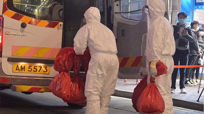 방역복을 입은 요원들이 애완동물 가게에서 햄스터 등의 사체를 옮기고 있다.