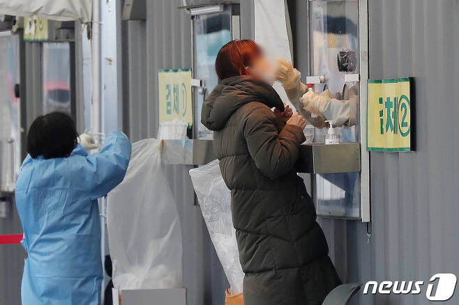 22일 오전 서울 중구 서울광장에 마련된 임시선별진료소를 찾은 시민들이 검체 검사를 받고 있다. 2022.1.22/뉴스1 © News1 민경석 기자