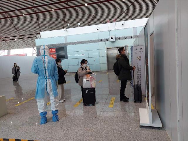 21일 인천국제공항을 떠나 중국 베이징의 서우두공항에 도착한 입국객들이 현지 의료진의 안내에 따라 유전자증폭(PCR) 검사를 받기 위해 줄을 서고 있다. 베이징=조영빈 기자