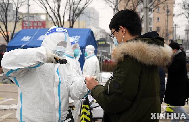 [베이징=신화/뉴시스] 중국 수도 베이징에서 24일 의료보건 요원이 코로나19 핵산검사를 받기 위해 대기 중인 시민들의 신원을 확인하고 있다. 2022.01.26