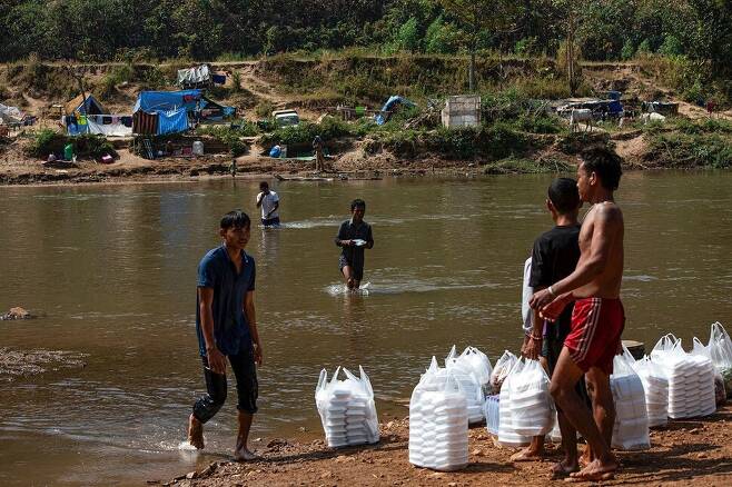 지난 15일 미얀마와 국경을 접하는 타이 매솟에서 미얀마 난민들이 구호품으로 식료품을 받고 있다. 매솟/AFP 연합뉴스