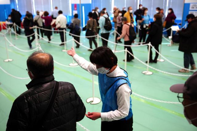 지난 22일 일본 도쿄 스카이트리에 마련된 코로나19 접종센터에 3차 접종을 하러 온 시민들이 줄을 서 있다. 도쿄=AP 연합뉴스