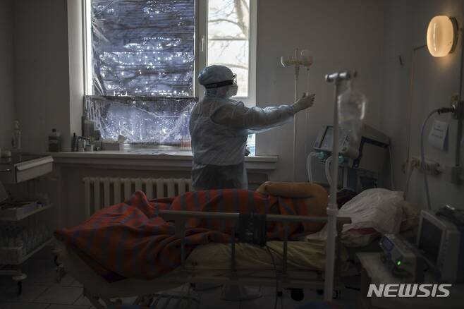 [모스크바=AP/뉴시스] 25일(현지시간) 러시아 남부 크라스노다르주 폴타프스카야 마을의 한 병원에서 의료진이 코로나19 환자를 치료하고 있다. 러시아 당국은 지난 2주 동안 코로나19 일일 확진자가 4배 이상 급증했다고 밝혔다. 2022.01.26.