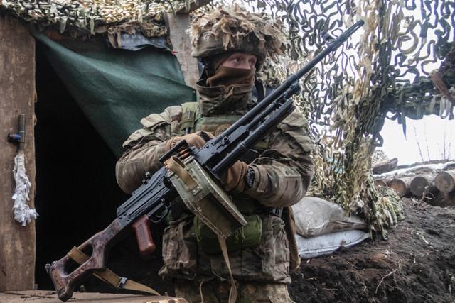 10일 우크라이나 도네츠크에서 친러시아 반군과 대치중인 한 정규군이 기관총을 들고 적진을 응시하고 있다. 도네츠크=AP 연합뉴스