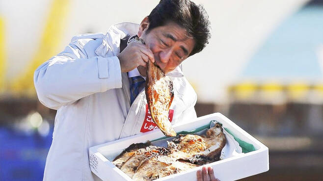 아베 신조(安倍晋三) 전 일본 총리가 후쿠시마(福島)산 식품이 안전하다는 것을 보여주기 위한 행사에 참석, 음식을 먹고 있는 모습. [연합]