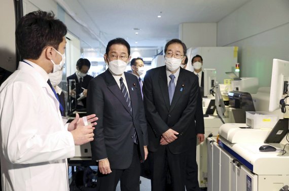 기시다 후미오 일본 총리(왼쪽 두번째)가 지난 12일 일본 도쿄 하네다 공항의 코로나 방역을 위한 격리 공간에서 관계자의 설명을 듣고 있다. AP뉴시스
